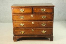 An 18th century George III oak chest of two short over three long graduated crossbanded drawers,