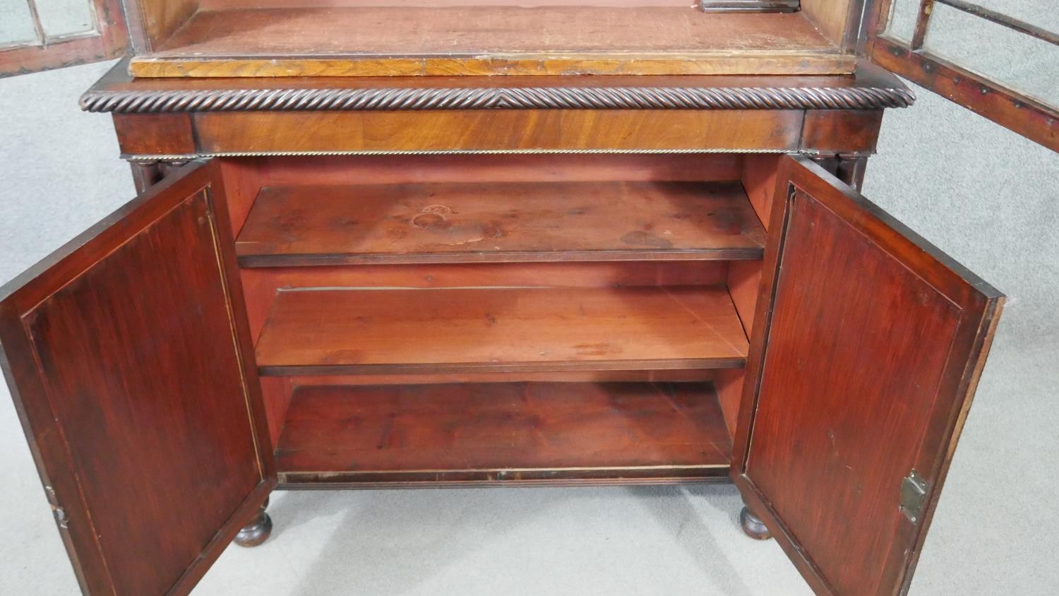 An early 19th century mahogany bookcase, with a gadrooned cornice over two glazed cupboard doors - Image 3 of 9