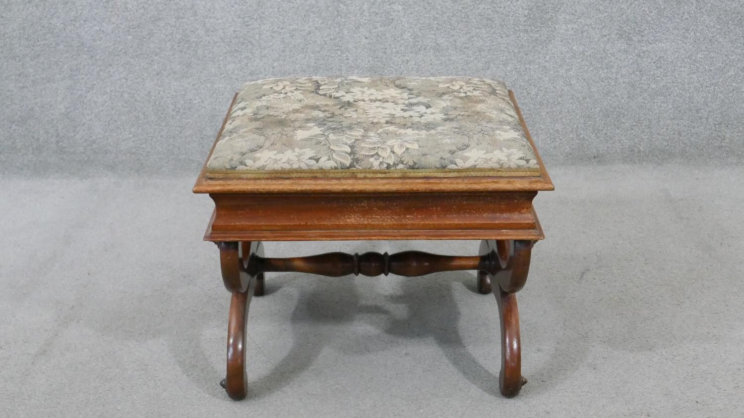 A Victorian walnut piano stool, the rising lid upholstered in machine made tapestry, on curved X