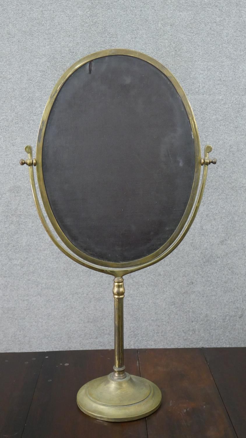 A large 20th century brass swing frame toilet mirror, with an oval mirror plate, on a circular base. - Image 3 of 6