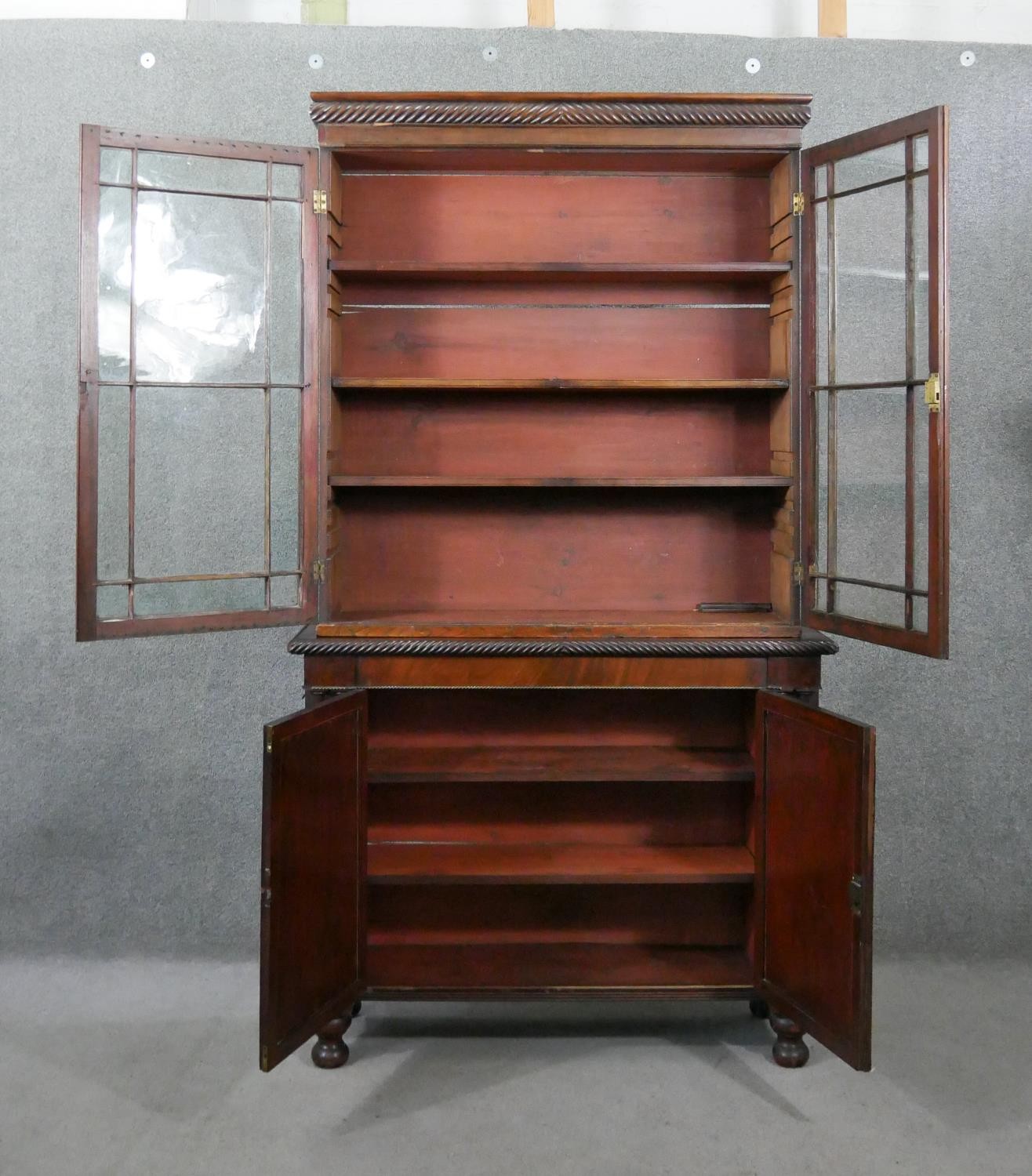 An early 19th century mahogany bookcase, with a gadrooned cornice over two glazed cupboard doors - Image 2 of 9