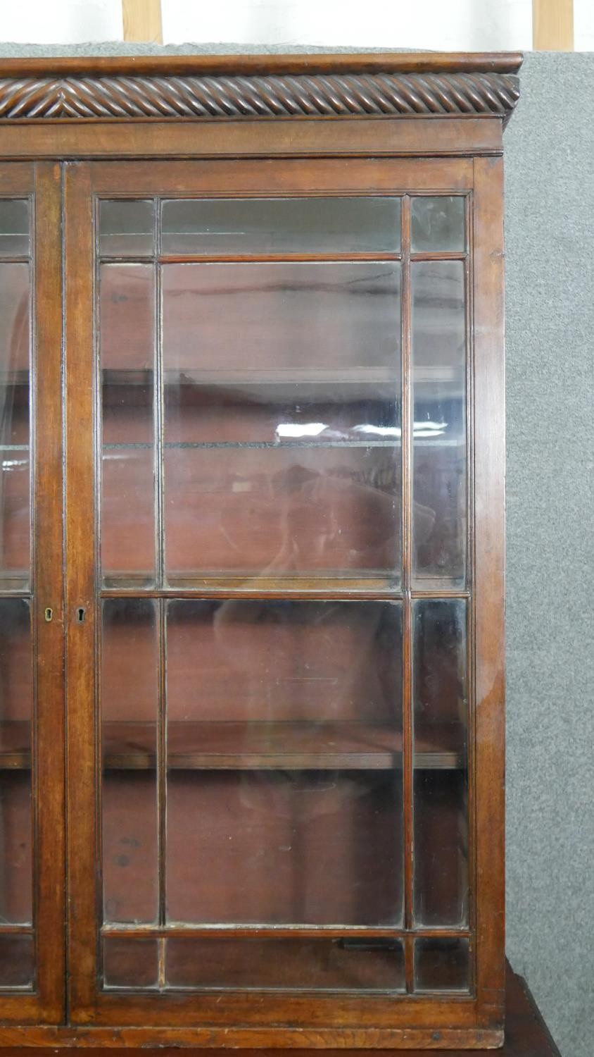 An early 19th century mahogany bookcase, with a gadrooned cornice over two glazed cupboard doors - Image 5 of 9