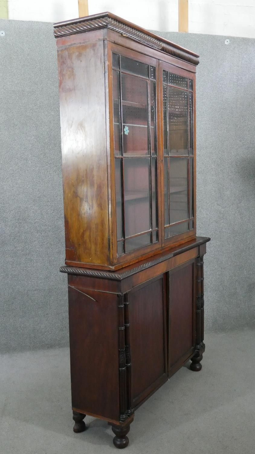 An early 19th century mahogany bookcase, with a gadrooned cornice over two glazed cupboard doors - Image 8 of 9