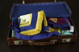 A brown leather carrying case containing various masonic items, including regalia and medals. H.20