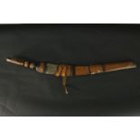 An African tribal sword and leather scabbard, with carved handle and engraved steel blade. L.90cm.