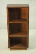 A 20th century teak bookcase of diminutive proportions, with two adjustable shelves, on a plinth
