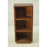 A 20th century teak bookcase of diminutive proportions, with two adjustable shelves, on a plinth