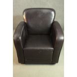 A contemporary brown leather club armchair, with piping to the back and arms, on tapering square