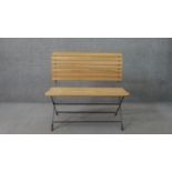 A contemporary folding garden bench, with a slatted seat and back, on a black painted iron frame.