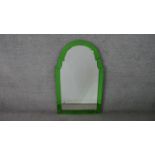 An Art Deco wall mirror, of rounded arch form, with a mirrored green bevelled frame. H.91 W.55cm