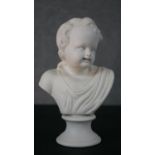 A Parian ware bust of a young boy on pedestal base, signed JOY, SW. H.19 W.12 D.8cm