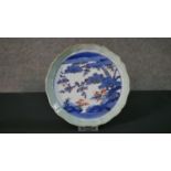 A Japanese 18th century porcelain plate with scalloped edge, celadon glaze border and landscape