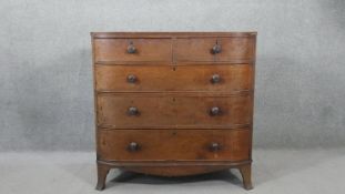 An early 19th century mahogany bow front chest of two short over three long graduated drawers with