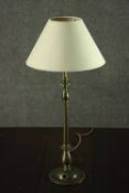 A turned brass table lamp, with an ivory coloured shade. H.56 W.25cm.