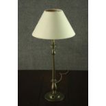 A turned brass table lamp, with an ivory coloured shade. H.56 W.25cm.