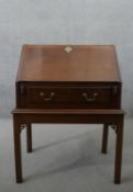 A George III mahogany bureau on stand, the fall front opening to reveal a central door,