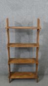 A set of pine open bookshelves, the four shelves joined to the shaped side with pegs. H.121 W.60 D.