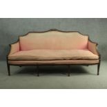An Adam style mahogany three seater sofa, the top rail centred by a carved urn, upholstered in
