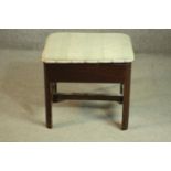 An early 20th century mahogany piano stool, upholstered in striped fabric, openening to reveal