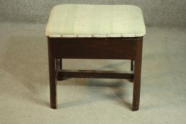 An early 20th century mahogany piano stool, upholstered in striped fabric, openening to reveal