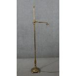 A Victorian brass adjustable floor standing reading lamp, with leaf detail to the fitting, on a