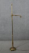 A Victorian brass adjustable floor standing reading lamp, with leaf detail to the fitting, on a