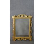 A carved giltwood Rococo design mirror, with a rectangular mirror plate, the frame with carved and