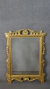 A carved giltwood Rococo design mirror, with a rectangular mirror plate, the frame with carved and