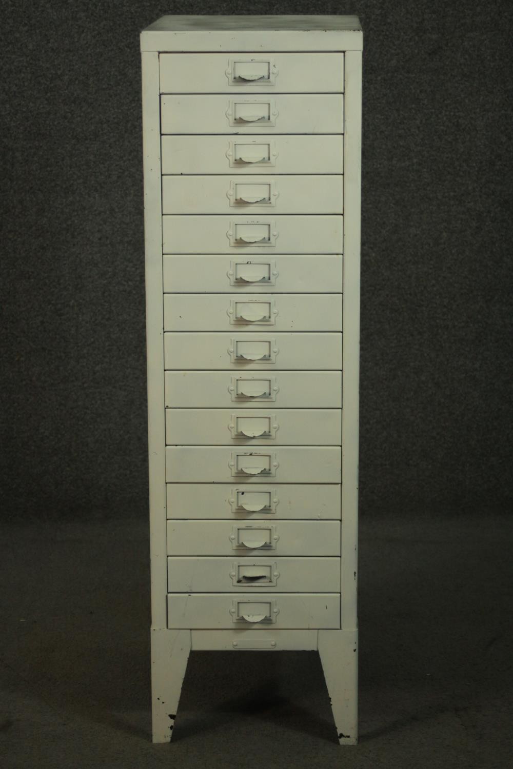 A 20th century white painted steel filing cabinet, with fifteen drawers, on tapering backet legs.