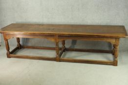 An 18th century oak refectory table, the plank top with cleated ends, on six turned and block