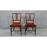 A pair of Edwardian walnut side chairs, the back with a carved foliate splat, over a red velour