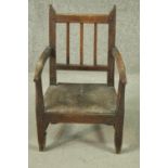 An early 19th century rustic elm child's armchair, the back with three spindles and open arms,