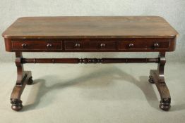 A Victorian mahogany library table, with three short drawers, over end supports joined by a turned