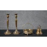 A collection of brass, including a pair of brass candlesticks with faceted design, a brass hand bell
