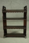 A late Victorian rustic hanging bookshelf, with shaped and pierced sides, the shelves with an