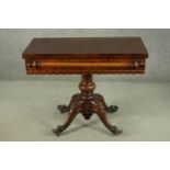 A Victorian figured walnut tea table, with a foldover top, over a baluster stem, on a quatraform