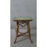 A wicker occasional table, the square top with green foliate Art Nouveau tiles, the splayed legs