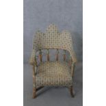 A wicker conservatory open armchair, with a triple hump back, on splayed legs joined by X stretchers