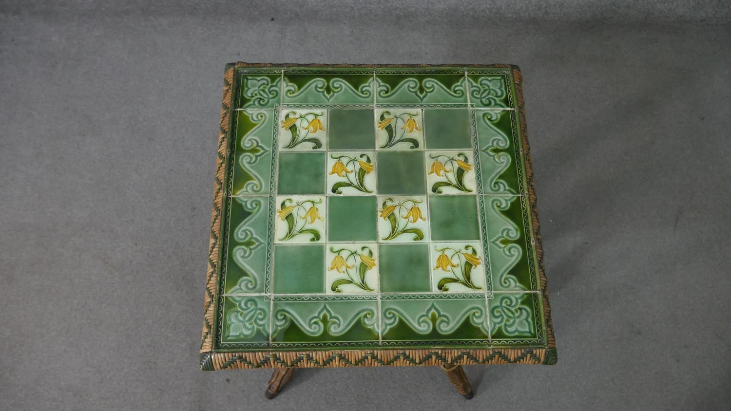 A wicker occasional table, the square top with green foliate Art Nouveau tiles, the splayed legs - Image 5 of 7