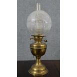 A Victorian brass converted oil lamp, with a globular etched glass shade. H.52 W.15cm