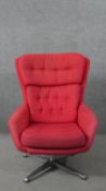 A mid 20th century swivel armchair, upholstered in red fabric, with buttoned back and seat, on a