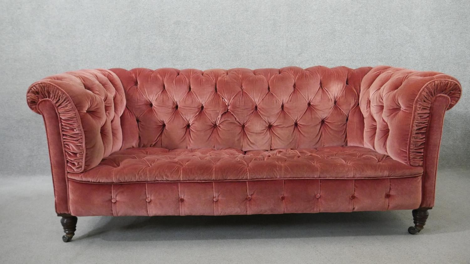 A Victorian Chesterfield sofa, upholstered in pink velour, buttoned to the back, arms, seat and