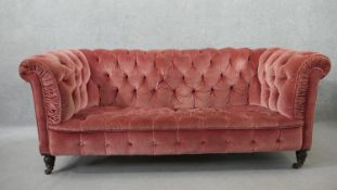 A Victorian Chesterfield sofa, upholstered in pink velour, buttoned to the back, arms, seat and
