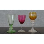 A Victorian cranberry glass wine glass, a green bubble glass with chicken stem and engraved with a