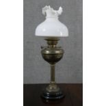 A Victorian brass oil lamp, with a milk glass shade, and a circular marble socle base. H.65cm