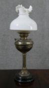 A Victorian brass oil lamp, with a milk glass shade, and a circular marble socle base. H.65cm