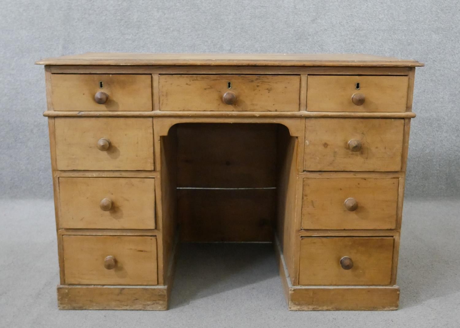 A Victorian pine kneehole desk, the rectangular top with a moulded edge, over an arrangement of nine