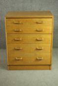 A circa 1950s utiity style chest, probably E Gomme, G-Plan, of five long graduated drawers, on a