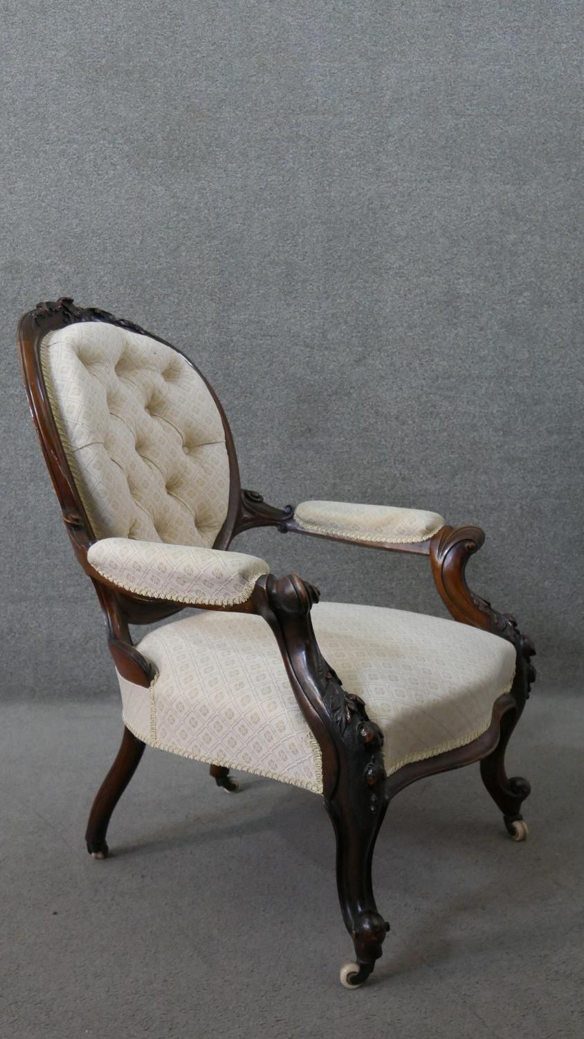 A Victorian walnut open armchair, upholstered in patterned ivory fabric, with an oval buttoned back, - Image 7 of 7