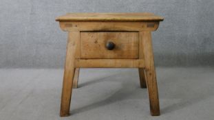 A 19th century rustic pine kitchen table, the single drawer with a knob handle, on splayed legs with